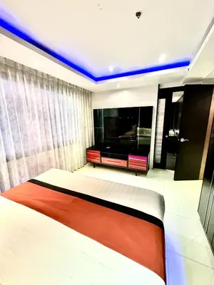 a bedroom with a bed and a flat screen tv at L08 Penthouse Suite Modern Condo On Bangla Road in Patong Beach
