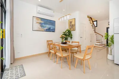 a dining room with a wooden table and chairs at Goldena Residence Private Pool Villas in Kamala Beach