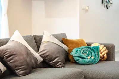 a couch with several pillows on it with a blue rose at Platinum Villa Rawai in Rawai Beach