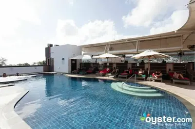a swimming pool with chairs and umbrellas on a building at L01 Bangla Suites Modern Studio On Bangla Road in Patong Beach