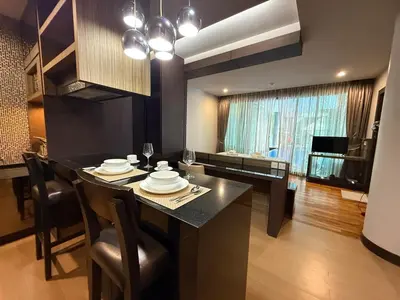a kitchen with a table with chairs and a dining room at The Regent Bang Tao Beach in Phuket