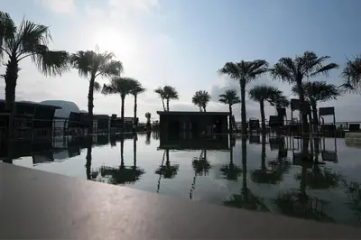 a pool of water with palm trees in the background at CityGate Condo in Magnificent Kamala Beach in Kamala Beach