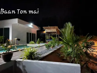 a house with a swimming pool and some palm trees at Baan ton mai 2 bedrooms 400 m from the beach in Klong Muang Beach