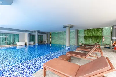 a swimming pool with two lounge chairs in a building at Majestic 2BR Residence with garden view in Regent in Bang Tao Beach