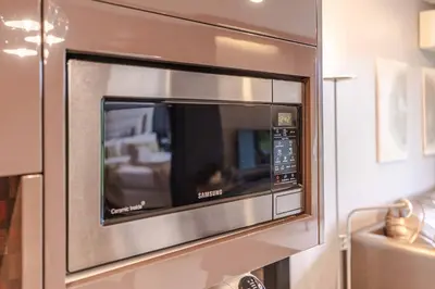 a microwave oven is attached to a wall at Majestic 2BR Residence with garden view in Regent in Bang Tao Beach