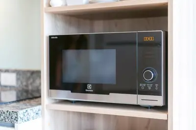 a microwave oven on a shelf in a kitchen at Diamond Bangtao Beach 1 bedroom in Bang Tao Beach