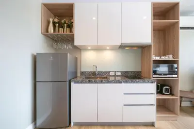 a kitchen with white cabinets and a refrigerator at Diamond Bangtao Beach 1 bedroom in Bang Tao Beach