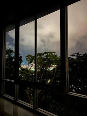 a window with a view of the city seen through it at Jungle House Phuket - Seaview Retreat in Patong Beach