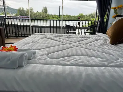a large white bed with towels on top of it at Riverside Hostel Phuket in Phuket Town