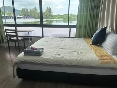 a bed in a room with a large window at Riverside Hostel Phuket in Phuket Town