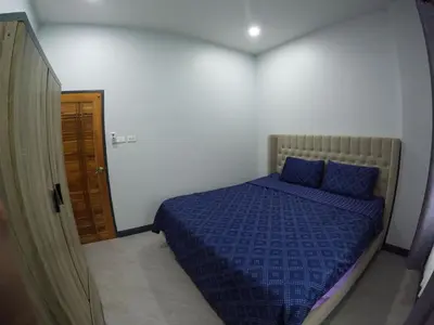 a bedroom with a bed with a blue comforter at Krabi Top Sea Hill Villa in Klong Muang Beach
