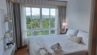a bedroom with a bed with a large window at Plus 2 condo by Tida 111 in Kathu