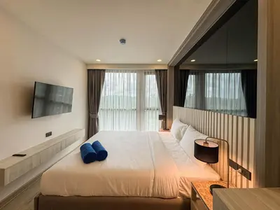 a bedroom with a large bed with blue pillows at Luxury Ozone Bang Tao 1 Bdr in Laguna Phuket
