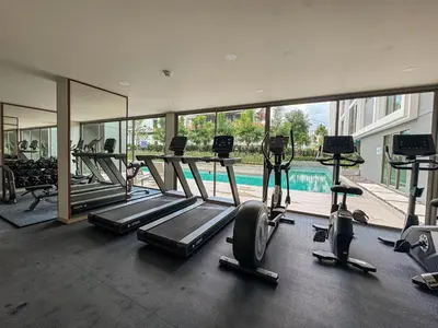 a gym with several treadmills and a swimming pool at Luxury Ozone Bang Tao 1 Bdr in Laguna Phuket