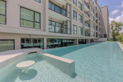 an empty swimming pool in front of a building at Space 404 - 1BDR with Coworking, Pool & Gym Access in Bang Tao Beach