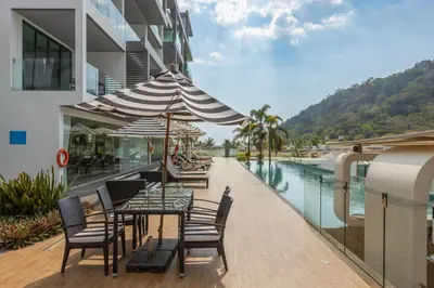 a patio with a table and chairs next to a pool at Spectacular two bed penthouse amazing sea views in Patong Beach