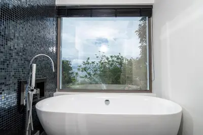 a bath tub in a bathroom with a window at Seascape 6BR Prestige Villa Skyline Pool in Kamala Beach