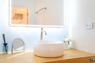 a bathroom with a white sink and a mirror at Stylish Studio with Pool - 8' walk to Rawai Beach - 
