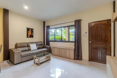 a living room with a couch and a window at V247 Poolside 1BR Near Naiharn Beach & Gym in Rawai Beach