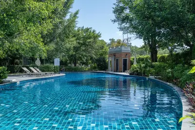 a swimming pool in a yard with trees at Cozy apartment by the sea F410 in Nai Yang Beach