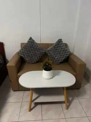 a couch with two pillows and a table at Hana apartment in Patong Beach