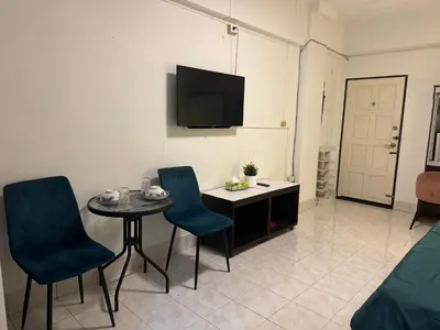 a living room with a table and chairs and a tv at Hana apartment in Patong Beach