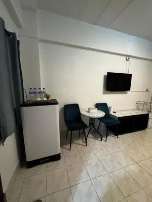 a room with a table and chairs and a tv at Hana apartment in Patong Beach