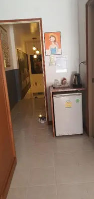 a kitchen with a small refrigerator and a hallway at Flowernight Guesthouse in Kata Beach