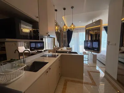 a kitchen with a sink and a living room at New studio of Bangtao Bellevue Lagoon 213 in Laguna Phuket