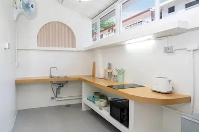 a kitchen with white walls and a wooden counter top at Stylish Studio with Pool - 8' walk to Rawai Beach - 