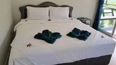 a bed with three blue pillows on it at Greenview Room and Restaurant
