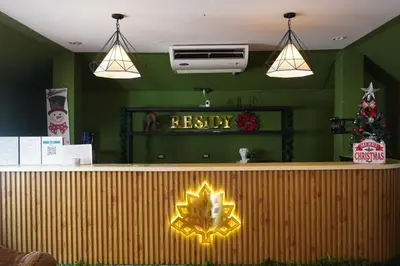 a restaurant with a reception counter with a christmas tree at Residy Downtown Hotel in Patong Beach