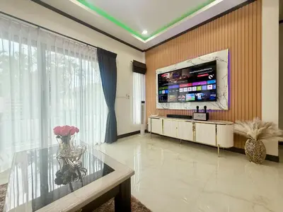 a living room with a tv and a glass table at PS House Bangtao in Bang Tao Beach