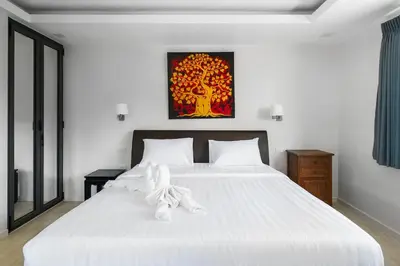 a bedroom with a large white bed with white sheets at Tilawan Villa by G Estate Phuket in Ban Klang