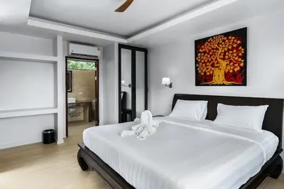 a bedroom with a white bed with a stuffed animal on it at Tilawan Villa by G Estate Phuket in Ban Klang