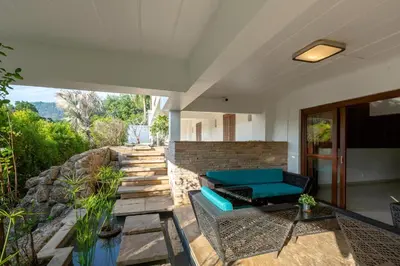 a living room with a blue couch on a patio at 50% Off Baan Angelo 3 Bed Pool Villa Kata Hill in Kata Beach