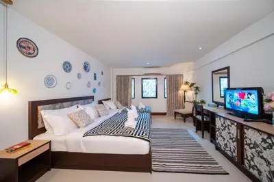 a bedroom with a large bed and a television at Nyonya Maison Boutique Hotel Phuket Old Town in Phuket Town