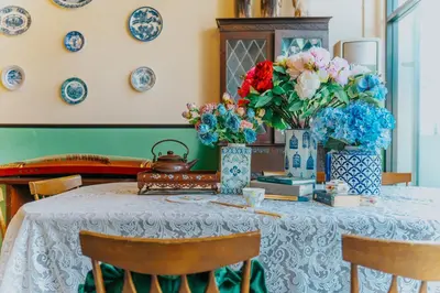 a table with two vases of flowers on it at Nyonya Maison Boutique Hotel Phuket Old Town in Phuket Town