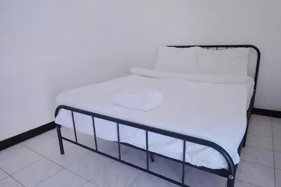 a bed with white sheets and white pillows on it at XX GO INN Patong Beach Phuket - โกอินน์ ป่าตอง in Patong Beach