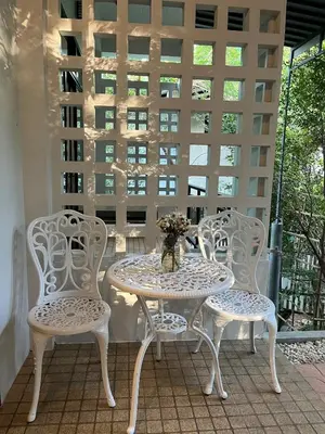 three chairs and a table on a balcony at Rawai Beach Villa in Nai Harn Beach