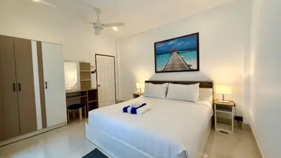 a bedroom with a large white bed with a blue towel on it at Secret Valley near Phuket Town in Kathu