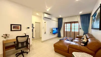 a living room with a brown leather couch and a desk at Secret Valley near Phuket Town in Kathu