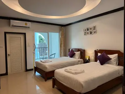 a bedroom with two beds and a large window at SVAH Boutique Patong in Patong Beach