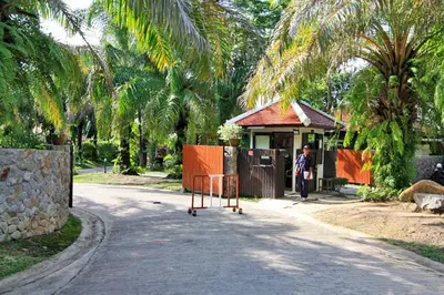 a man is standing in front of a house at Tropical Poolside Villa - SGB4 in Phuket Town