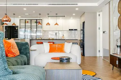 a living room with a white couch and orange pillows at Sunshine by Villacarte in Layan Beach