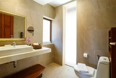 a bathroom with a sink and a toilet and a mirror at Seafront Pool Villa Nambo in Ko Taphao Noi