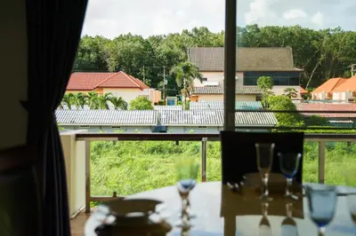 a table with wine glasses and a view from a window at Condominium Rawai D1 - near convenience beach, market, gym in Rawai Beach
