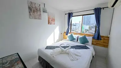 a bedroom with a bed with a bow on it at MT friendhome&hostel2 in Phuket Town