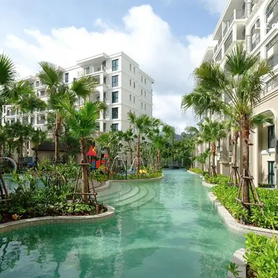 a canal in a resort with palm trees and buildings at The Title Legendary Bang Tao Beach in Phuket
