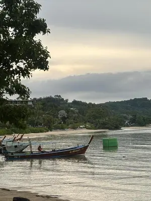 a boat in the water next to a beach at Chaota Modern House in Ban Ao Makham